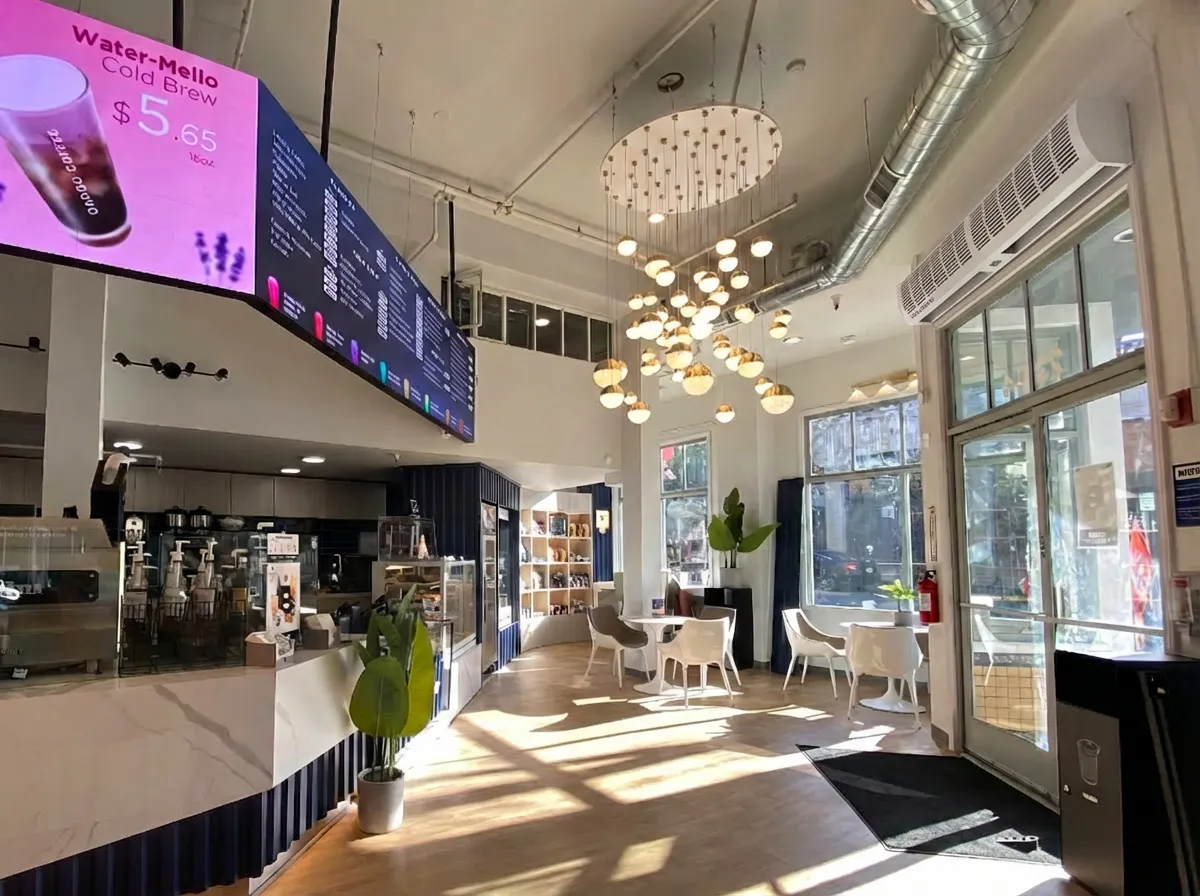 Commercial air curtain installed above a café entrance door to prevent outdoor air, dust, and insects while maintaining indoor comfort.